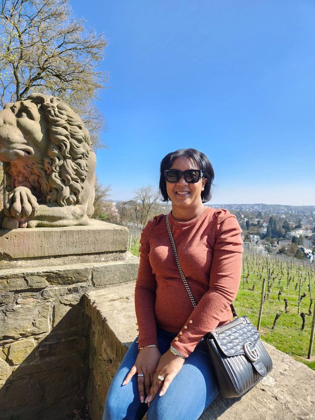 Tamica beside a stone lion above a vineyard in Germany