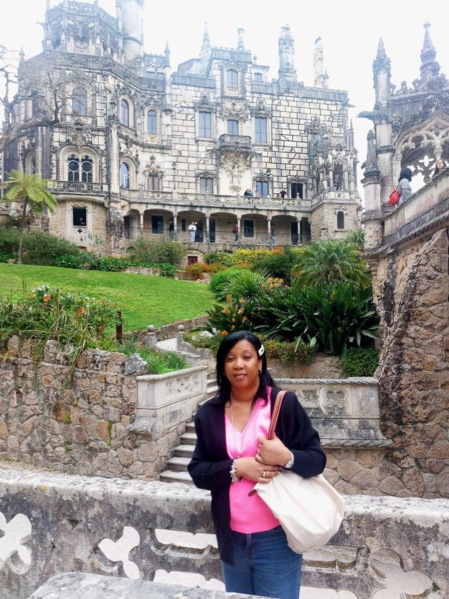Tamica in front of an ornate stone palace and garden in Portugal