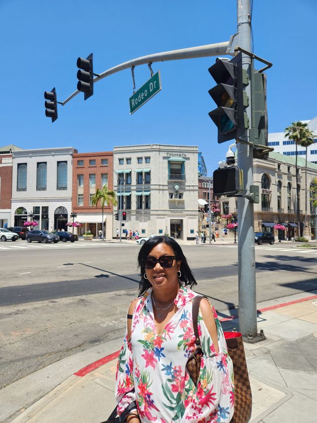 Tamica on a corner of Rodeo Drive in a bright floral blouse