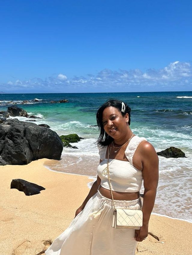 Tamica on a sandy beach in Maui in a white outfit