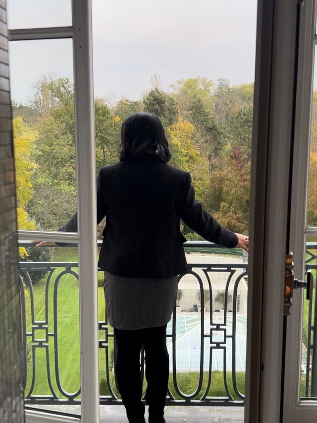 Tamica on a balcony at Versailles, looking out over autumn trees